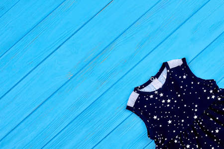 Pretty baby dress and copy space. Casual little lady outfit on blue wooden background. Clothing for small girl.の写真素材