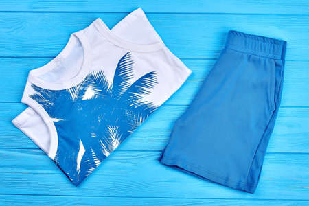 Kids natural summer clothes. Set of high quality childs apparel on blue wooden background. Children brand garment on sale.の写真素材