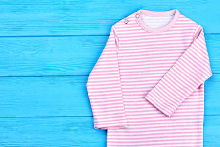 Close up of striped bodysuit for baby. Natural cotton long sleeve romper for baby-girl, copy space. Infant cotton romper.の写真素材