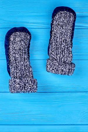 Top view of pair wool socks. Warm knitted socks inverted up on blue wooden background, vertical image.の写真素材