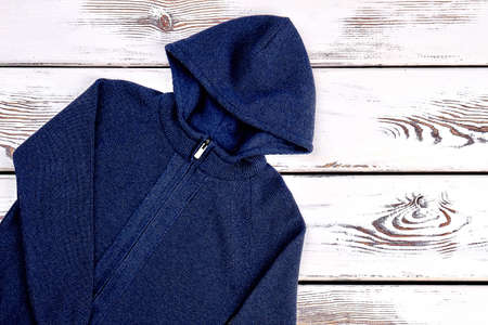 Dark blue knit cardigan. Brand hooded jacket for little boys on old wooden background. Childrens outfit on sale.の写真素材