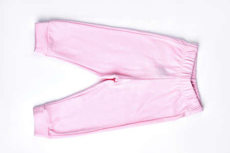 Baby-girl light pink trousers. Top view of new cotton pants for infant girl, isolated on white background.の写真素材