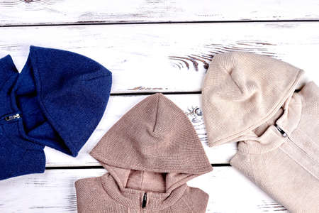 Collection of hooded knitted sweaters, top view. Cotton knit pullovers with hoodies for childrens on sale. Warm knit jumpers.の写真素材