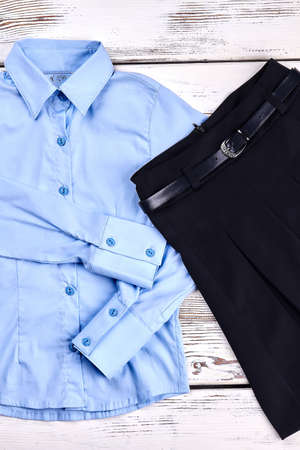 Girls modern school uniform. Girls brand long sleeve blouse and black pleated skirt with belt for school. Girls classic fashion garment for school.の写真素材