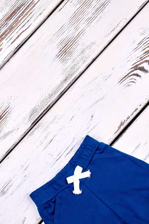 Kids short cotton pants. Baby new brand shorts isolated on old wooden background, copy space.の写真素材