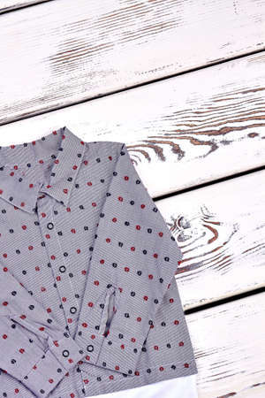 Little boy new patterned shirt. Toddler boy grey dot print cotton shirt on wooden background. Kids fashion outfit.の写真素材