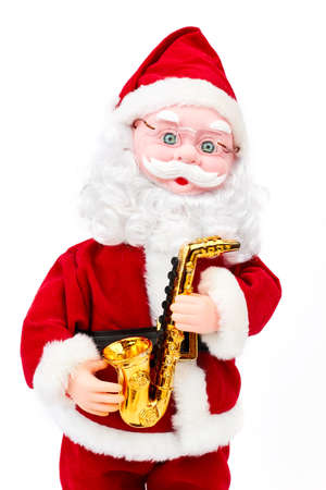 Close up shot of Santa Claus doll. Beautiful grandfather frost with golden saxophone isolated over white background. Symbol of New Year. New Year decorative toy.の写真素材