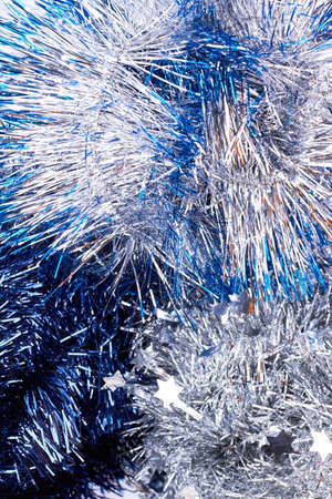 Close up blue and silver tinsels. Classic Christmas festive glitter garlands close up. Christmas shiny tinsels background.の写真素材