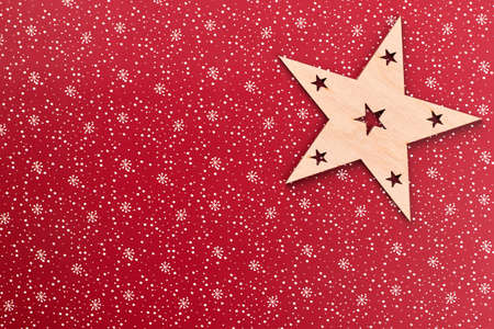 Carved wooden star and copy space. Cut out wooden Christmas decoration on red New Year festive...
