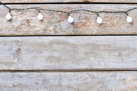 Christmas rustic background. Christmas and New Year lights on old wood background and copy space.
