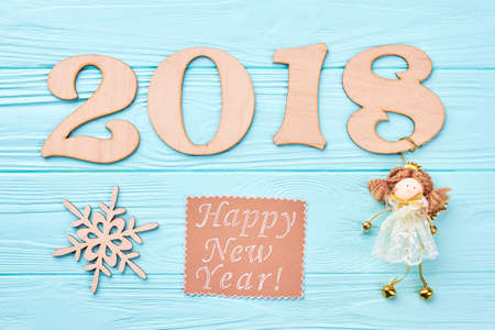 New Year 2018 blue wooden background. Wooden number 2018, wooden cut out snowflake, message and angel figurine on blue wooden background. Happy New Year 2018.の写真素材