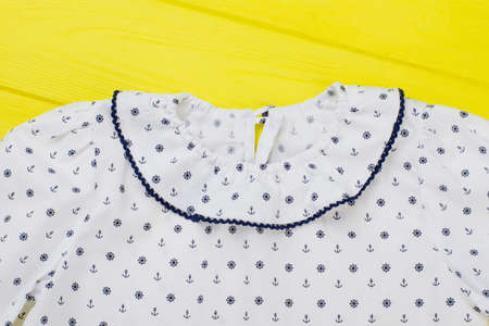 Close up on kids pajama over yellow background. Collar with edging and nautical pattern. Girls clothing and sleepwear.の写真素材