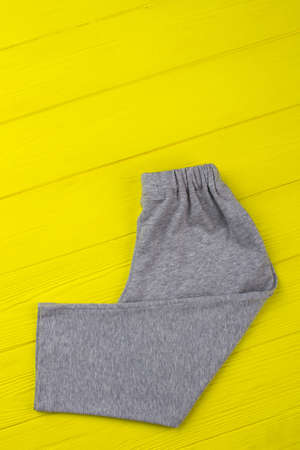 Gray sweatpants on yellow shelf. Loose-fitting and elastic waist. Comfy clothing for boys.の写真素材