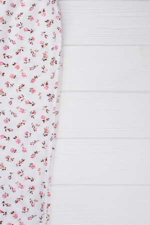 Floral print on white fabric. Close up on folded garment at the store. Textile shop.