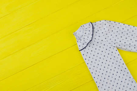 White nightie with collar decorated with edging and sailor pattern. Colorful yellow background. Discount on girls collection.の写真素材