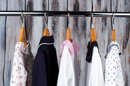 Kids pajamas in a wardrobe. Clothes on wooden hangers. Fashion for little ones, sleepwear and robes.の写真素材