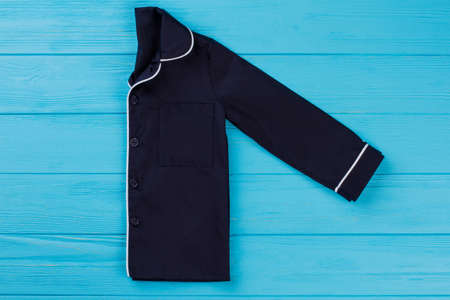 Pajamas shirt folded in half. Elegant navy top with thin white stripes. Fashionable nightwear for boys.の写真素材