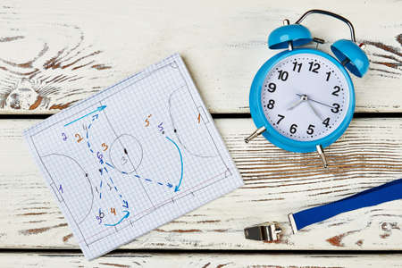 Development of game strategy. Notebook with drawn tactics, whistle and table clock. Work of football coach.の写真素材