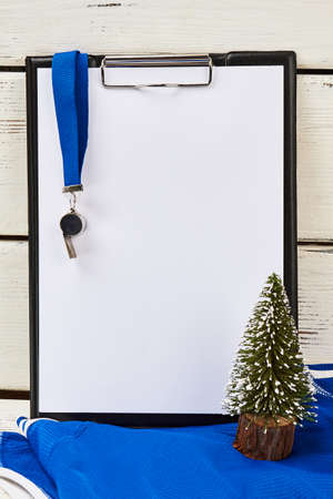 Coachs clipboard and whistle. Christmas tree miniature. Teams results of the year concept.