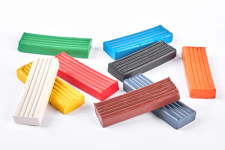 Multicolor material for kids craft. Heap of children bright plasticine on white background. Set of...