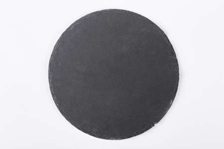 Slate stone tray, top view. Round slate stand isolated on white background.の写真素材