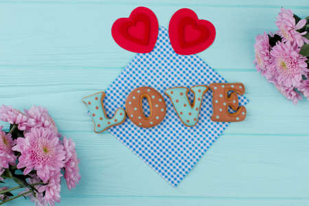 Valentines Day love cookies and paper hearts. Decoration for Valentines Day on blue wooden background, top view.の写真素材