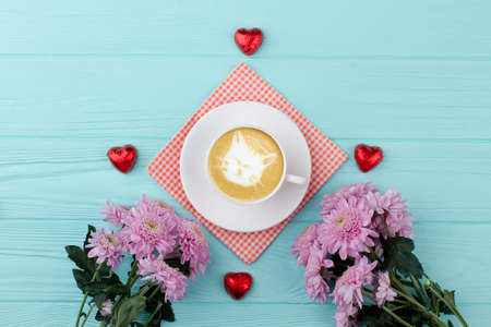 Valentines Day composition on wooden background. Cup of cappuccino and chocolate hearts, pink...