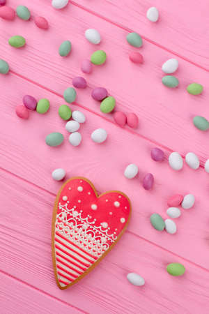 Composition with candies and cookie. Valentines Day pink wooden background with sweets, top view.