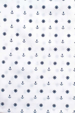 Sailor pattern over white fabric. Anchor and handwheel. Stylish textile for girl and boys clothing.