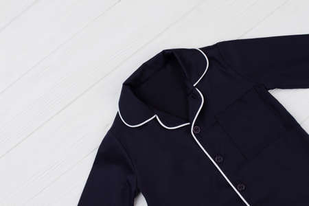 Plain blue shirt on wooden background. Rounded collar with white edging. Boys clothing.の写真素材