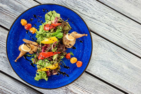 Warm salad with quail, eggs and nut sauce. Structure of a salad top view.