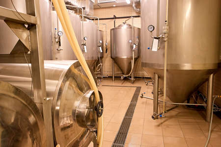 Steel brewery kettles indoor. Beer plant with brewing kettles.