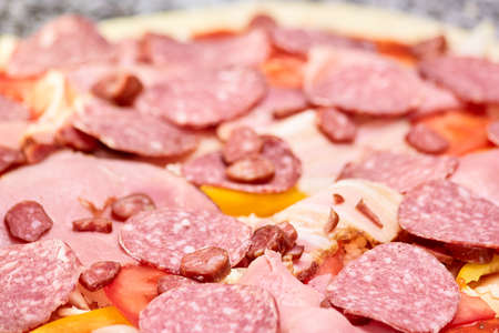 Pile of salamis, hams and hunting sausages closeup. Close up large pile of sliced cold meats.の写真素材