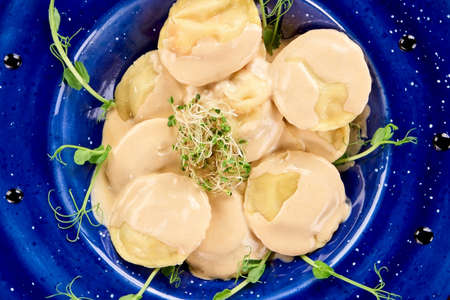 Dish with ravioli close up. Decorated ravioli on blue plate.の写真素材