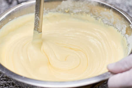 Stirring batter in bowl, close up. Metal mixer mixing around batter.の写真素材