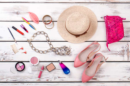 Woman fashion accessories, top view. Female summer hat, shoes and beauty items on white wooden background. Fashion lady summer set.の写真素材