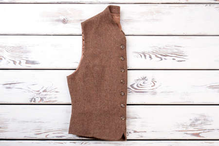 Women vest folded on wooden background. Female woolen waistcoat and copy space. Woman vintage outfit on sale.の写真素材