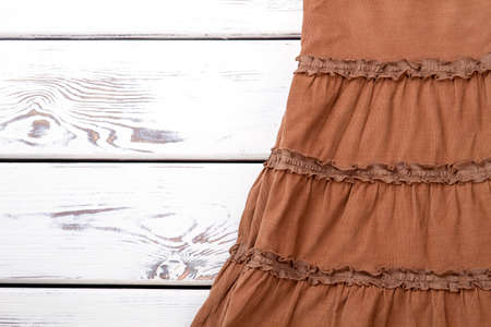 Babycord brown skirt, wooden background. Vintage skirt on white wooden table, space for text.の写真素材