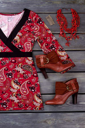 Flatlay feminine clothes and accessories. Women printed blouse, ankle boots and necklace. Female fashion look on wooden background.の写真素材