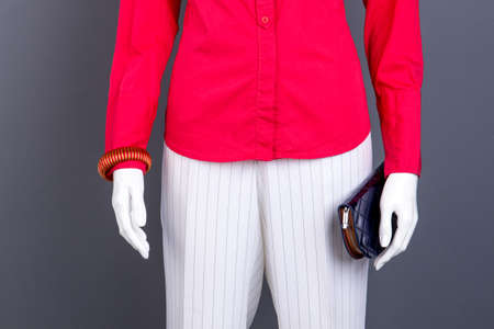 Red blouse, bracelet and wallet. Female red shirt and white striped trousers. Women classic outfit.の写真素材