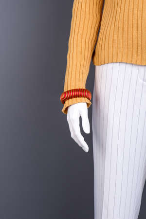 Mannequin with female bracelet, copy space. Close up women sweater and trousers on mannequin,...