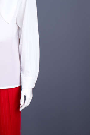 Female mannequin in elegant clothing, copy space. White blouse and red trousers, cropped image. Female fashion and style.の写真素材