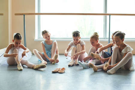 Group of young ballerinas preparing for performance. Six young ballet girls in ballet studio.の写真素材