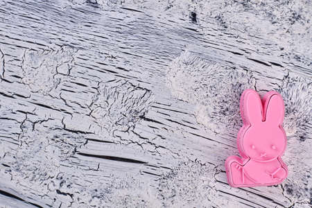 Silicone mold for baking, copy space. Pink rabbit shaped silicone mold form for cakes on grey textured background, top view.の写真素材