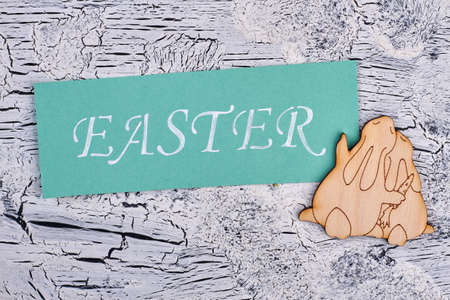 Turquoise Easter card, plywood rabbits. Colorful Easter card and couple of plywood bunnies on grey textured background. Creative Easter congratulation.の写真素材