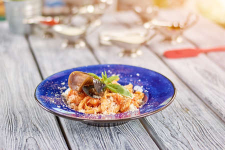 Delicious pasta frutti di mare. Appetizing italian pasta with seafood and fresh basil. Tasty dish on restaurant table.の写真素材