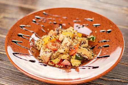 Appetizing salad served with sauce. Delicious salad with barbecued vegetables and chicken. Tasty dinner on plate.の写真素材