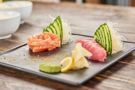 Delicious salmon and tuna sashimi set. Sliced salmon and tuna on traditional japanese plate. Restaurant of japanese food.の写真素材