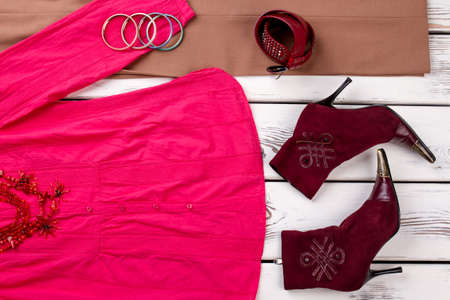 Pink womens shirt and burgundy boots. Close up concept of female cloth, top view,の写真素材