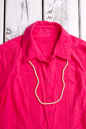 White balls necklace on pink shirt. Close up blouse collar with jewelry.の写真素材